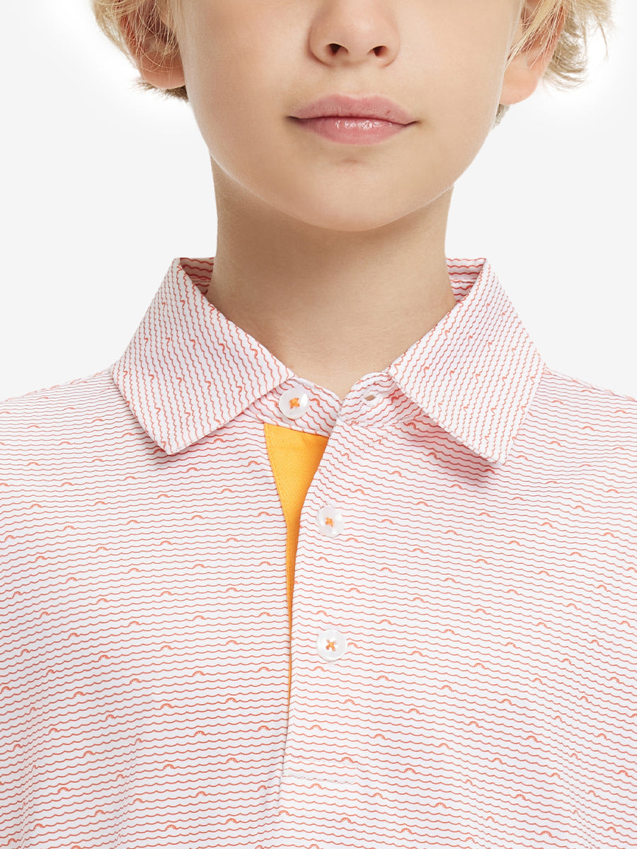 Close-up front view from nose to chest of boy wearing ORANGE SEA WAVE Performance Print Boys Golf Polo