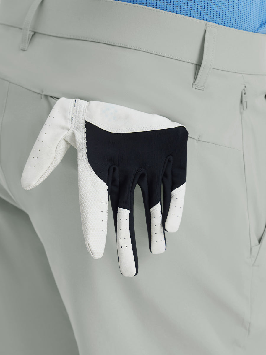 Back view of Player Fit Versatile Solid Shorts 7 Inch with golf glove tucked into right pocket – NEUTRAL GREY
